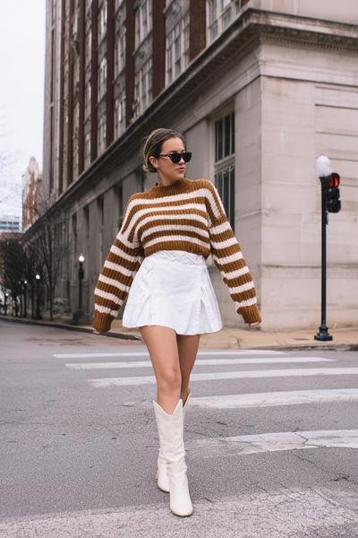 6. Brandy Striped Sweater Outfit with White Mini Skirt and Boots