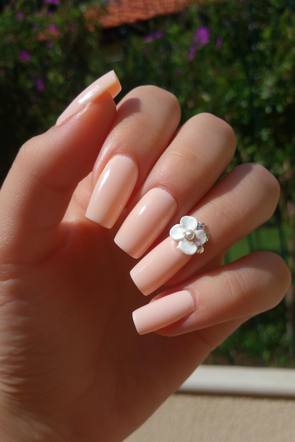 18. Pretty Acrylic Nails Peachy Nude with Blossom Accent