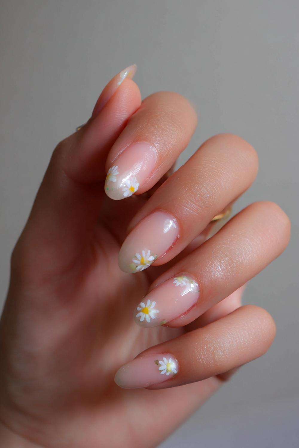 7. Baby nail inspo with milky peach base and micro-daisy corners